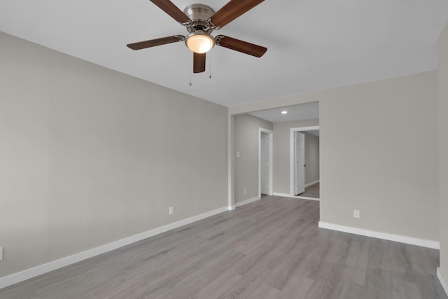 spare room with baseboards, a ceiling fan, and wood finished floors