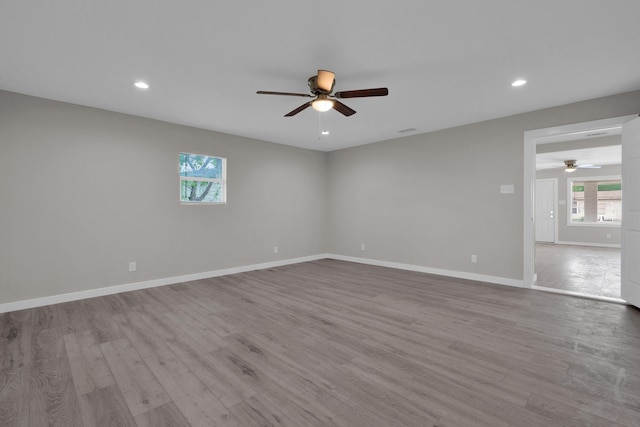 spare room featuring recessed lighting, ceiling fan, wood finished floors, and a healthy amount of sunlight