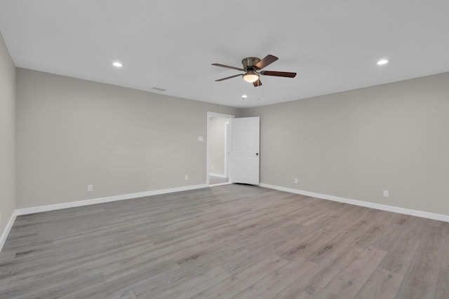 unfurnished room featuring ceiling fan, visible vents, wood finished floors, baseboards, and recessed lighting