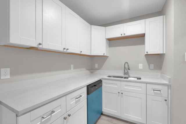 kitchen featuring white cabinets, a sink, and dishwashing machine