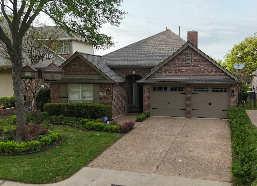 view of front of house with an attached garage, concrete driveway, brick siding, and a chimney