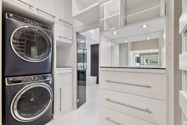 1619 Villa Ct, Corinth, TX 76210 - clothes washing area with stacked washer / dryer, cabinet space, and light marble finish floors