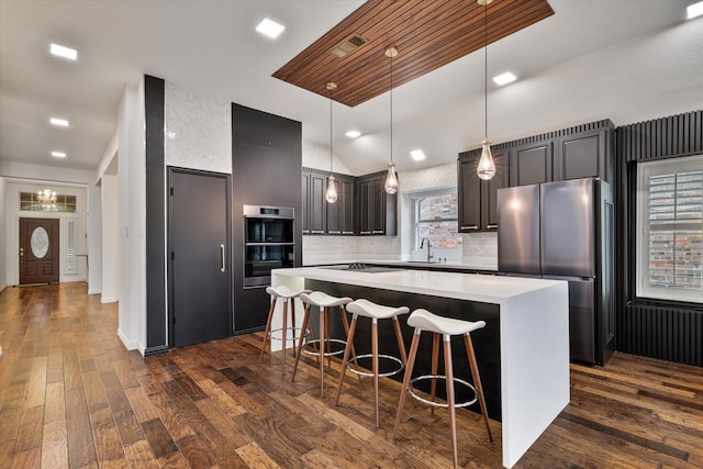 1619 Villa Ct, Corinth, TX 76210 - kitchen featuring appliances with stainless steel finishes, a center island, dark wood-type flooring, light countertops, and a sink