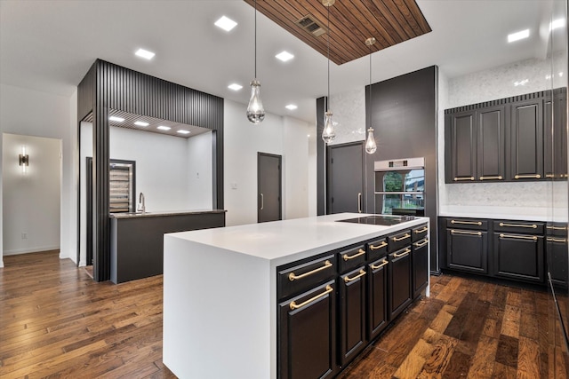 1619 Villa Ct, Corinth, TX 76210 - kitchen featuring dark wood finished floors, a kitchen island with sink, light countertops, hanging light fixtures, and decorative backsplash