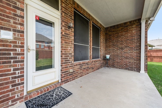 doorway to property featuring brick siding and a patio