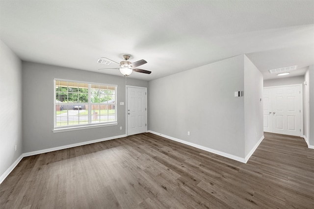 spare room with baseboards, visible vents, and wood finished floors