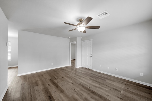 empty room with baseboards, a ceiling fan, wood finished floors, and visible vents