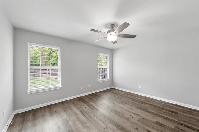 spare room featuring baseboards, ceiling fan, and wood finished floors