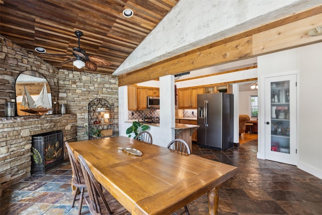 dining room with wooden ceiling, ceiling fan, vaulted ceiling, and stone tile floors