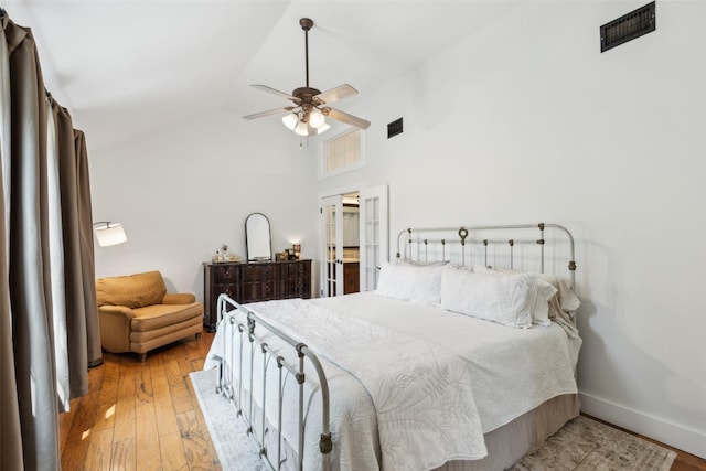 bedroom with a ceiling fan, baseboards, visible vents, and hardwood / wood-style floors