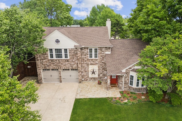 view of front facade featuring a front lawn, a chimney, a shingled roof, an attached garage, and driveway