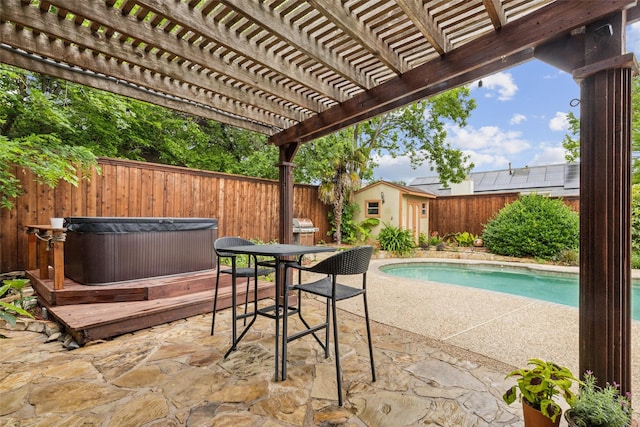 view of patio / terrace with a pergola, a hot tub, a fenced backyard, a fenced in pool, and an outbuilding
