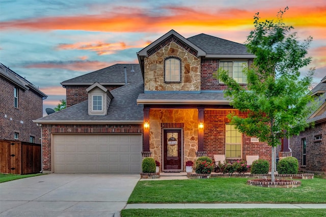 traditional home with a front lawn, roof with shingles, driveway, and stone siding