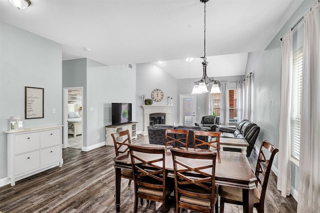dining space featuring baseboards, a fireplace, and dark wood-style floors