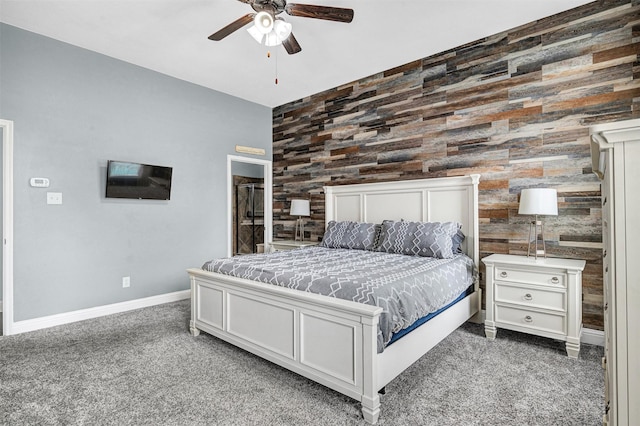 carpeted bedroom with baseboards, wood walls, and ceiling fan