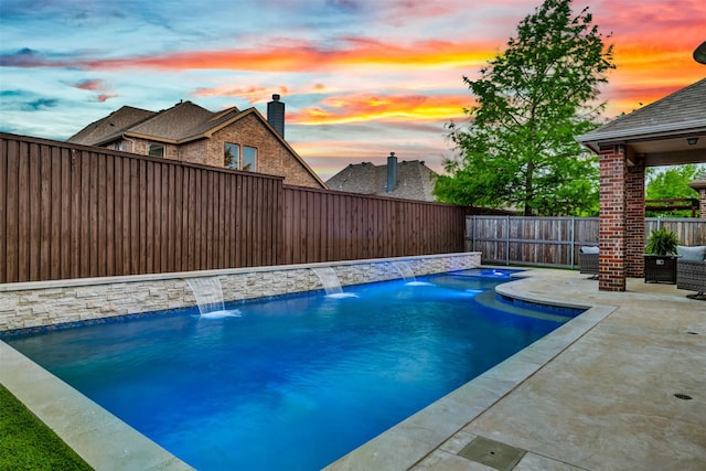 pool at dusk with a patio, a fenced in pool, and a fenced backyard