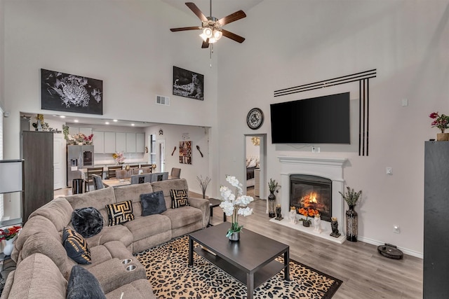 2561 Pettus Dr, Forney, TX 75126 - living area with ceiling fan, visible vents, light wood-type flooring, baseboards, and a high ceiling
