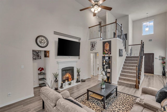 2561 Pettus Dr, Forney, TX 75126 - living area with ceiling fan, high vaulted ceiling, baseboards, wood finished floors, and stairway