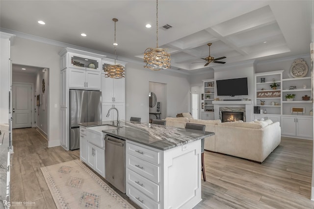 kitchen with a ceiling fan, a sink, stone counters, stainless steel appliances, and white cabinetry