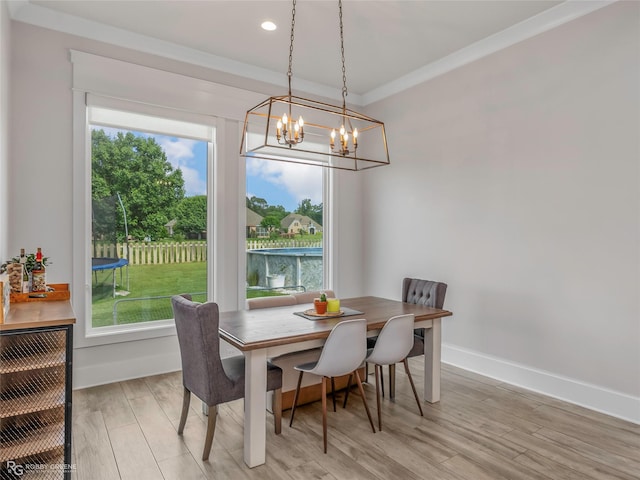 dining area featuring a healthy amount of sunlight, baseboards, light wood-type flooring, and a chandelier