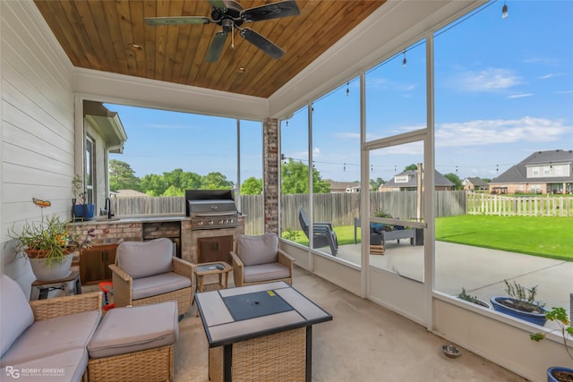 sunroom / solarium with exterior kitchen, outdoor lounge area, and a ceiling fan
