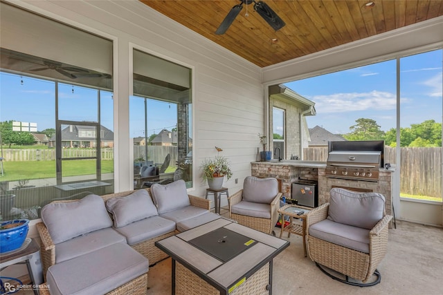 sunroom with an outdoor kitchen, a ceiling fan, an outdoor living space, and a wealth of natural light