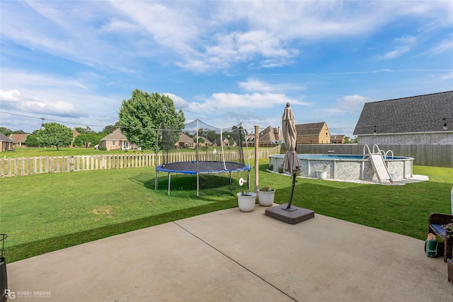 view of patio with a fenced backyard, a fenced in pool, and a trampoline