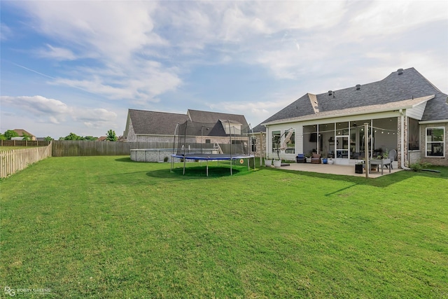 view of yard with a fenced backyard, a trampoline, and a patio area