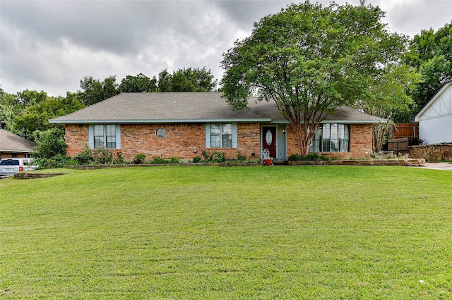 ranch-style house featuring brick siding and a front yard
