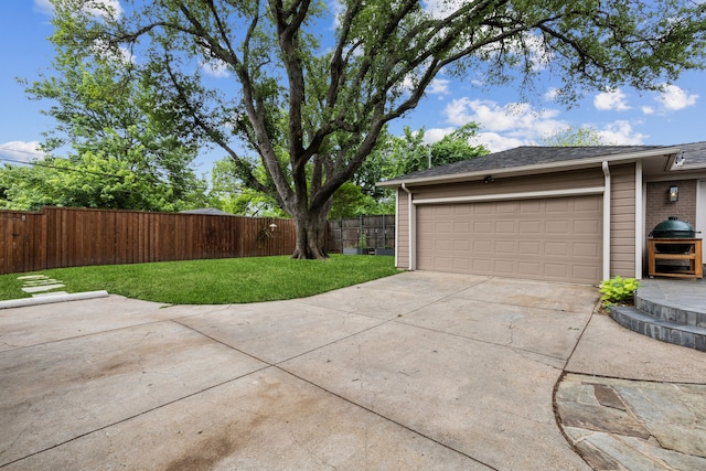 garage featuring fence and driveway