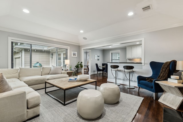 living area featuring visible vents, ornamental molding, and wood finished floors