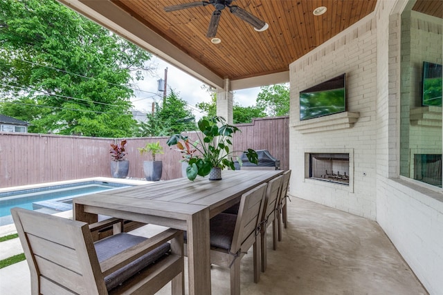 view of patio with outdoor dining space, ceiling fan, a fenced backyard, a fenced in pool, and an outdoor brick fireplace