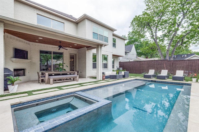 view of swimming pool featuring a patio, a ceiling fan, an outdoor living space with a fireplace, and fence