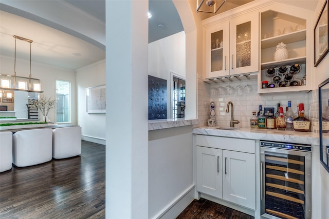 bar with wet bar, tasteful backsplash, dark wood finished floors, a sink, and wine cooler