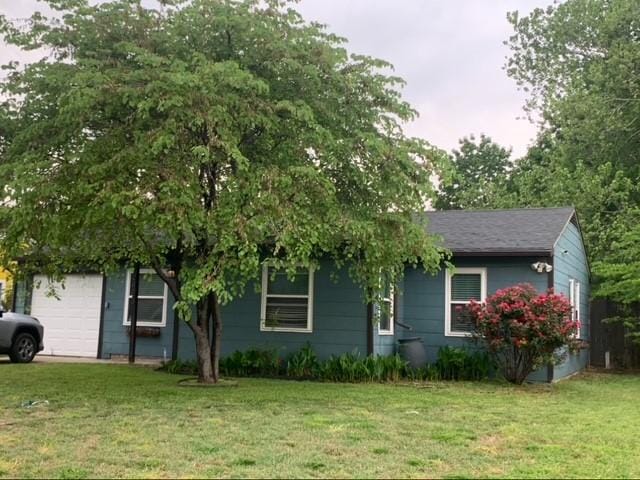 view of front of home featuring an attached garage and a front lawn