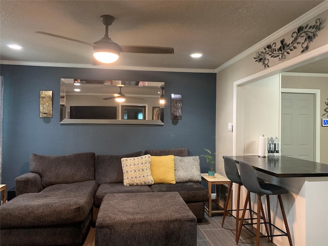 living area with a ceiling fan, a textured ceiling, recessed lighting, and ornamental molding