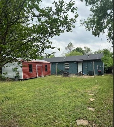 back of property featuring an outdoor structure, a yard, and cooling unit