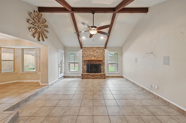 unfurnished living room featuring beam ceiling, tile patterned flooring, a fireplace, high vaulted ceiling, and a ceiling fan