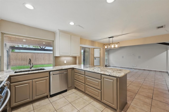 kitchen featuring a sink, dishwasher, stove, a peninsula, and light tile patterned floors
