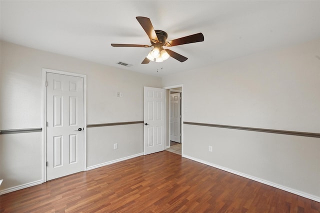 unfurnished bedroom with a ceiling fan, baseboards, visible vents, and wood finished floors