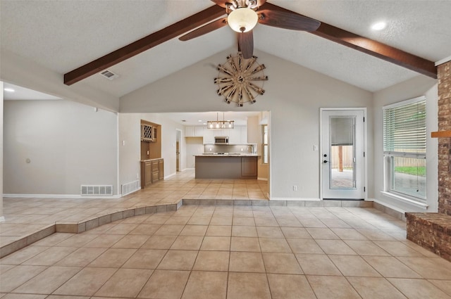 unfurnished living room featuring light tile patterned floors, beamed ceiling, ceiling fan with notable chandelier, and visible vents