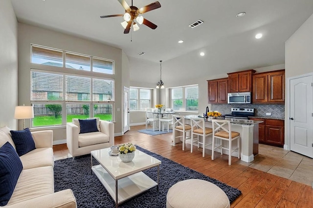 5012 Spruce St, Krum, TX 76249 - kitchen with visible vents, decorative backsplash, a kitchen island with sink, a ceiling fan, and stainless steel appliances