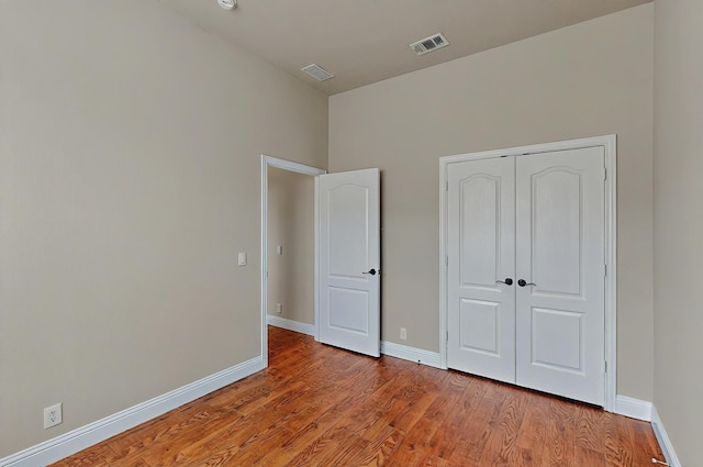 unfurnished bedroom with baseboards, visible vents, light wood-style flooring, and a closet