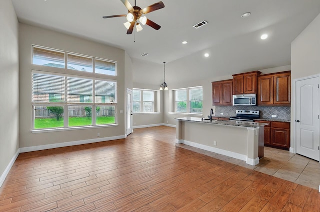 5012 Spruce St, Krum, TX 76249 - kitchen featuring visible vents, stone countertops, high vaulted ceiling, a sink, and appliances with stainless steel finishes
