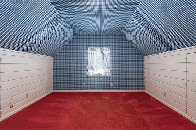 additional living space featuring vaulted ceiling, baseboards, and carpet flooring