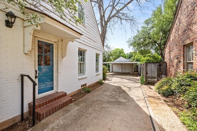 view of patio with an outdoor structure, a garage, fence, and entry steps
