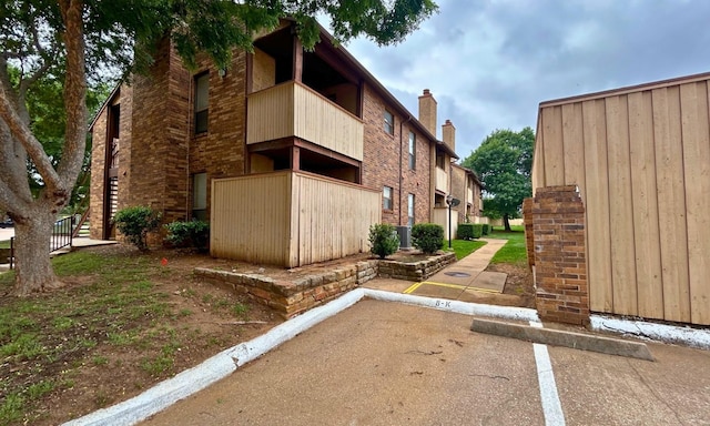 view of property exterior with uncovered parking