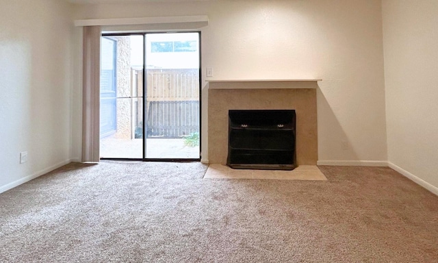 unfurnished living room with baseboards and carpet