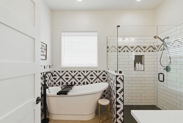 bathroom with a freestanding bath, tile patterned floors, recessed lighting, tile walls, and a stall shower