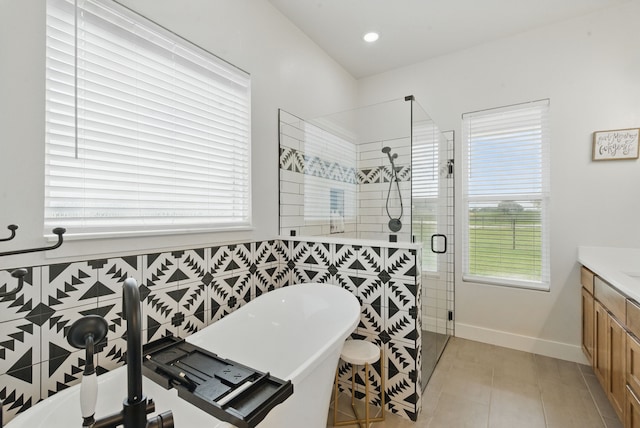 bathroom with vanity, plenty of natural light, a soaking tub, and a stall shower